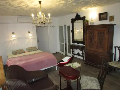 a bedroom with a bed and a chandelier at PragueCityApartment in Prague