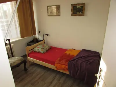 a small bedroom with a bed with a red blanket at PragueCityApartment in Prague