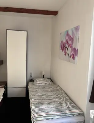 two beds in a white room with a picture on the wall at Ubytování Hoštka in Hošťka