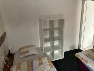 a bedroom with two beds and a book shelf at Ubytování Hoštka in Hošťka