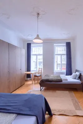 a bedroom with two beds and a table in it at Apartments Vezenska in Prague