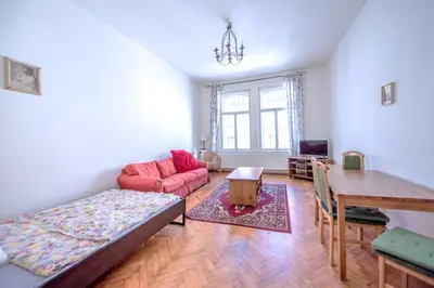 a living room with a red couch and a table at Apartments Vezenska in Prague