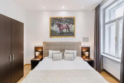 a bedroom with a bed and a painting on the wall at Premiere Dubcek Apartment in Prague