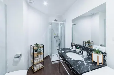 a bathroom with a sink and a shower at Premiere Dubcek Apartment in Prague