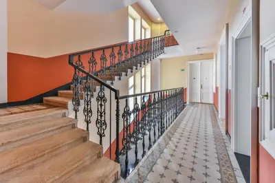 a staircase in a home with a wrought iron railing at Premiere Dubcek Apartment in Prague