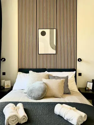 a bedroom with towels on a bed with a striped wall at Rentero modern Apartment, 10 minutes Charles bridge, Prague in Prague