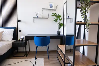 a bedroom with a desk and two blue chairs at Rentero modern Apartment, 10 minutes Charles bridge, Prague in Prague
