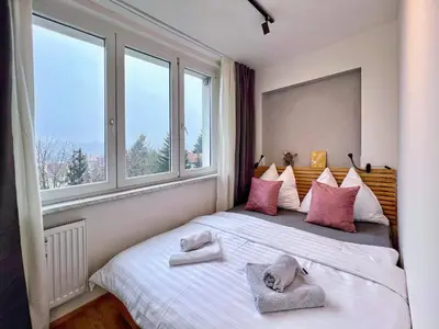 a bedroom with a large bed with pillows and windows at Jana's WOW apt, 3 room, free parking, 15'Airpt, 25'City in Prague