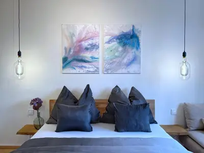 a bedroom with a bed with three paintings on the wall at Jana's WOW apt, 3 room, free parking, 15'Airpt, 25'City in Prague