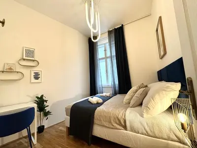 a small bedroom with a bed and a window at Rentero Royal blue Wenceslas Apartment, Prague in Prague