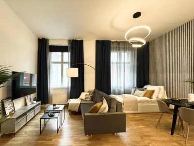 a living room with a couch and a table at Rentero Royal blue Wenceslas Apartment, Prague in Prague
