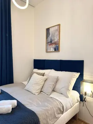 a bed with a blue headboard in a room at Rentero Royal blue Wenceslas Apartment, Prague in Prague