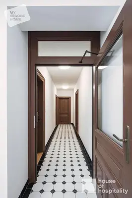 a corridor with a door and a black and white tile floor at MY SECOND HOME by House of Hospitality in Prague