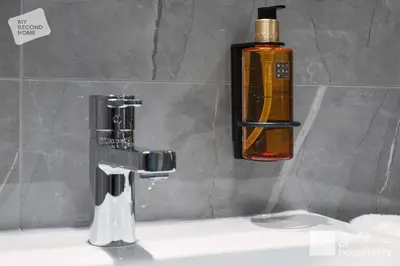 a bathroom sink with a soap dispenser on the wall at MY SECOND HOME by House of Hospitality in Prague