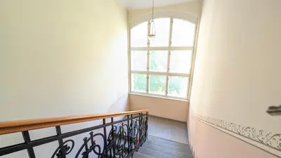 a hallway with a staircase with a window at Riverside Gem w Balcony View in Prague