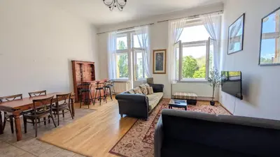 a living room with a couch and a table at Riverside Gem w Balcony View in Prague