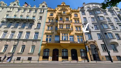a yellow building in front of two white buildings at Riverside Gem w Balcony View in Prague