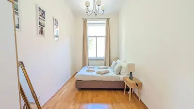 a small bedroom with a bed and a window at Riverside Gem w Balcony View in Prague