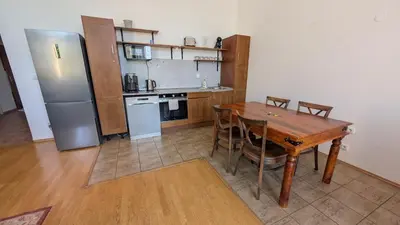 a kitchen with a wooden table and a refrigerator at Riverside Gem w Balcony View in Prague