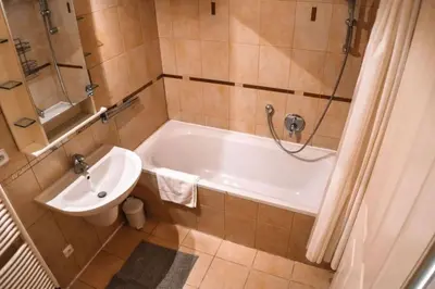 a bathroom with a tub and a toilet and a sink at Central Riverside Duplex loft in Prague