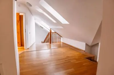 an attic room with a staircase and a white ceiling at Central Riverside Duplex loft in Prague