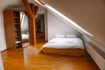 a bedroom with a bed and a staircase with a mirror at Central Riverside Duplex loft in Prague
