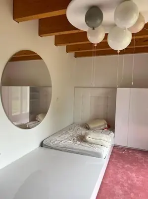 a white room with a bed and a mirror at Klokočná in Klokočná
