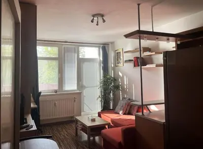 a living room with a red couch and a window at Praha 5 Barrandov- Apartmán Daniela in Prague