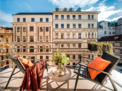 a balcony with chairs and a table and a building at Wenceslas sq SOHO Boutique Hotel & Premium Suites in Prague