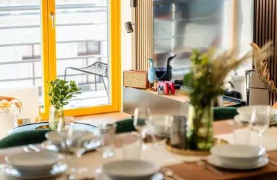 a table with plates and glasses and a window at Wenceslas sq SOHO Boutique Hotel & Premium Suites in Prague