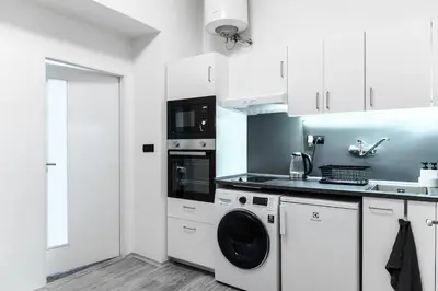 a white kitchen with a washing machine in it at Apartmen-Квартира in Prague