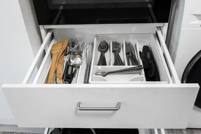a white drawer with utensils in it at Apartmen-Квартира in Prague