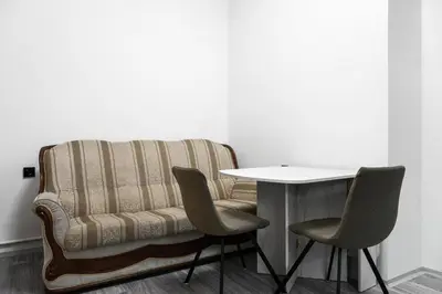 a table and two chairs next to a couch at Apartmen-Квартира in Prague