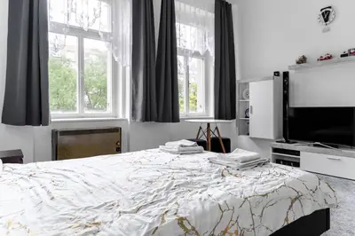 a bedroom with a bed and a flat screen tv at Apartmen-Квартира in Prague