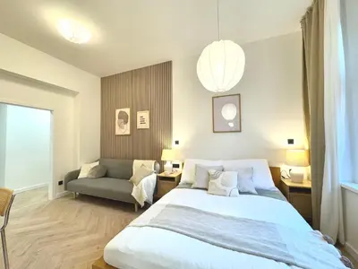 a bedroom with a large bed and a couch at Rentero Golden Wabi-Sabi Apartment, Prague in Prague