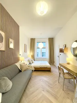 a bedroom with a couch and a bed and a desk at Rentero Golden Wabi-Sabi Apartment, Prague in Prague