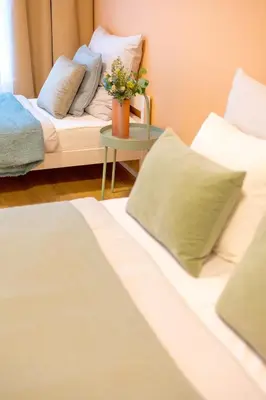 a room with two beds and a table with a couch at Spacious 3BR - 2 Parking Spots, Full Kitchen, by Gravity Prague in Prague