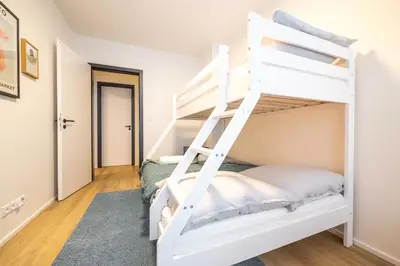 a bedroom with a white bunk bed in a room at Spacious 3BR - 2 Parking Spots, Full Kitchen, by Gravity Prague in Prague