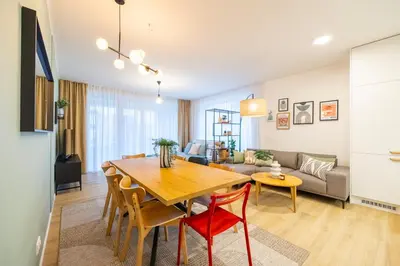a living room with a table and a couch at Spacious 3BR - 2 Parking Spots, Full Kitchen, by Gravity Prague in Prague