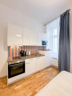 a kitchen with white cabinets and a stove at TurnKey I Wenceslas Square Apartments in Prague
