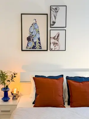 a bedroom with four pictures above a bed with orange pillows at TurnKey I Wenceslas Square Apartments in Prague