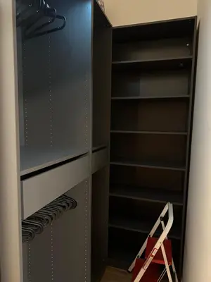 a walk in closet with black shelves at Pasta Party Apartment, Free Parking, Fully Equipped in Prague
