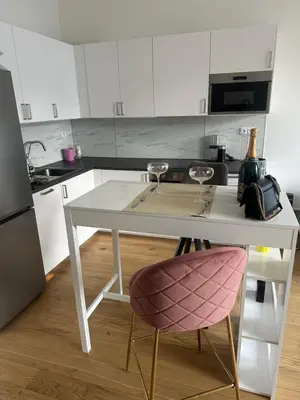a kitchen with a white table and a pink chair at Pasta Party Apartment, Free Parking, Fully Equipped in Prague