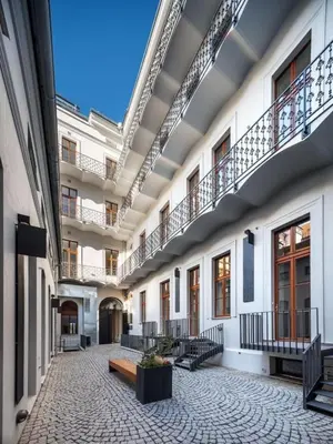 an empty courtyard of a building with stairs and benches at Opletalova Residence 1min from Wenceslas Square in Prague