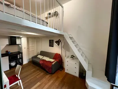a living room with a couch under a loft bed at Opletalova Residence 1min from Wenceslas Square in Prague