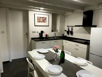 a kitchen with a table with plates and flowers on it at Opletalova Residence 1min from Wenceslas Square in Prague