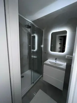 a white bathroom with a shower and a sink at Saint Petr in Prague