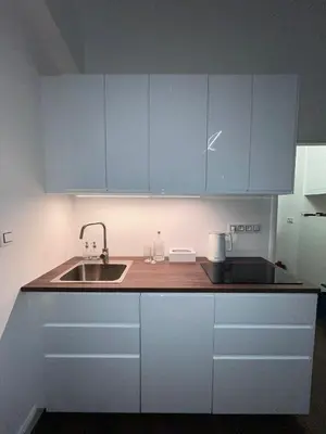 a kitchen with white cabinets and a sink at Saint Petr in Prague