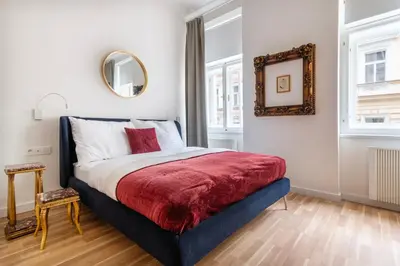 a bedroom with a bed with a red blanket and a mirror at J3 Prague Apartments in Prague