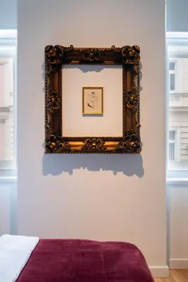 a picture frame on a wall above a bed at J3 Prague Apartments in Prague